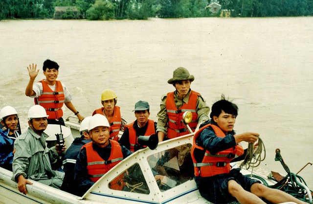 Ông Nguyễn Sự (đứng- nón tai bèo) trong một chuyến cứu hộ lũ lụt năm 2000. (Ảnh: Phước Bình/ Lao Động)