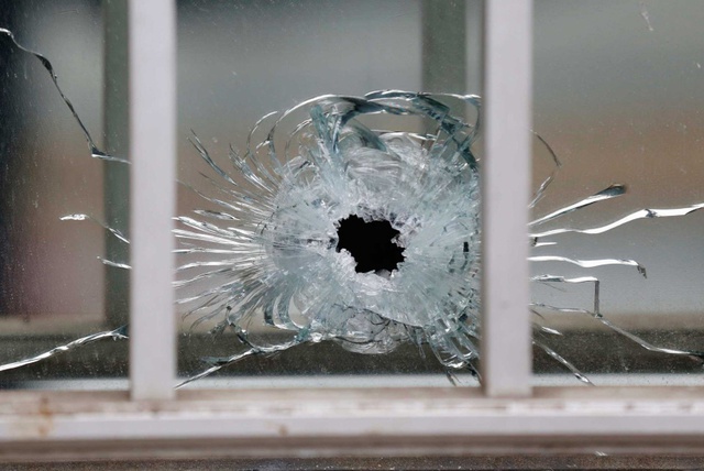 Một viên đạn xuyên qua cửa kính văn phòng tòa soạn. Ảnh: AFP