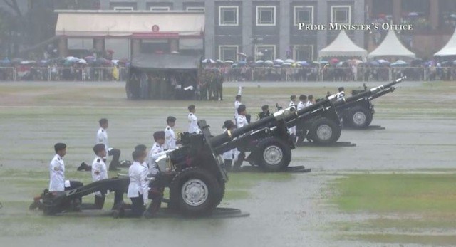 The procession is turning into Parliament Place. The first round of a 21-gun salute will soon be fired from four ceremonial howitzers on the Padang.