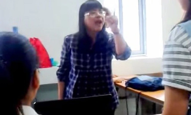 Cô giáo Lê Na (đeo kính) đang chỉ thẳng tay vào mặt học viên nói học viên vô học. (Ảnh cắt từ clip)