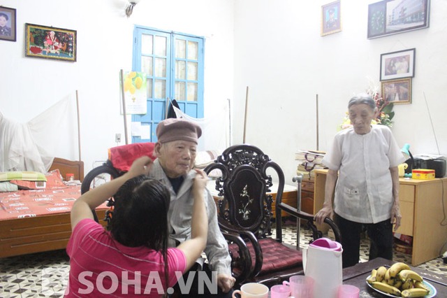 Trong lúc người cháu giúp ông mặc áo thì vợ ông, bà Nguyễn Thị Nhì (năm nay 95 tuổi) luôn ở bên cạnh.