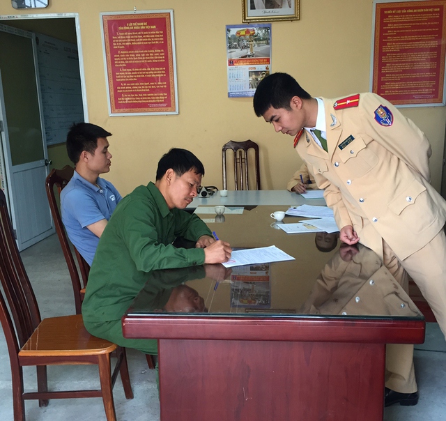 Tài xế Trần Văn Tuyên đang ký vào biên bản xử phạt.