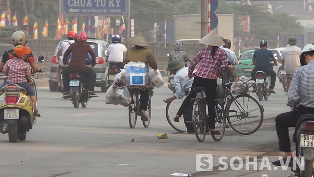 Một người đàn ông đang đi xe đạp nhưng cũng bất ngờ cúi xuống nhặt tiền