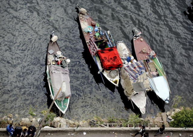 Ngư dân phải dùng chăn che thuyền của họ do thời thiết giá rét trên sông Nile ở thành phố Cairo, Ai Cập.