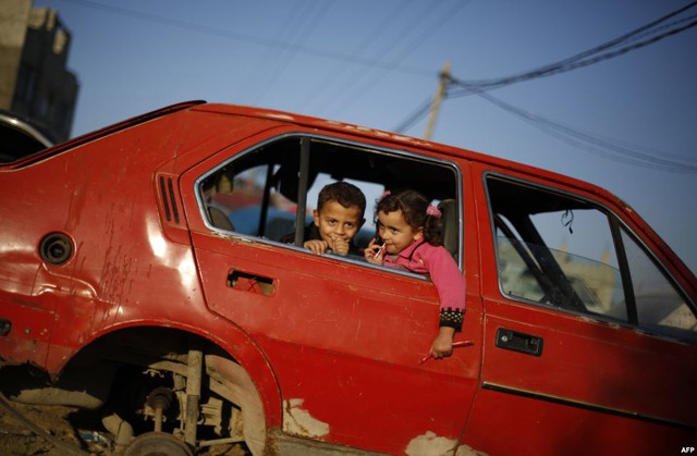 Trẻ em Palestine chơi trong chiếc ô tô hỏng ở ngoại ô thị trấn Al-Shejaiya, thành phố Gaza.