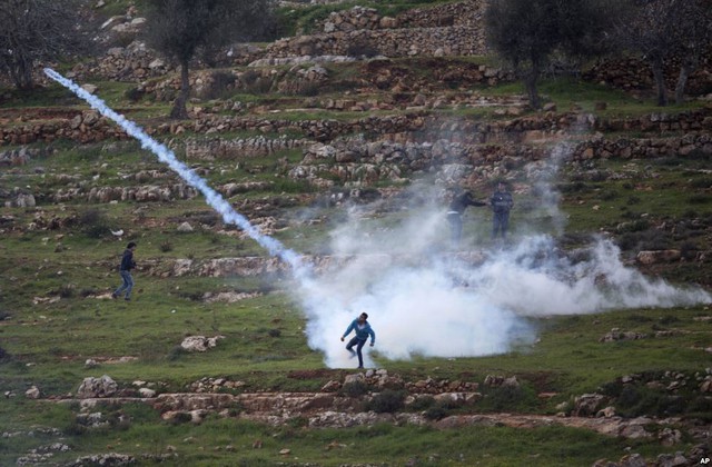 Người biểu tình Palestine ném lựu đạn hơi cay trở lại quân đội Israel trong cuộc đụng độ tại thành phố Ramallah, Bờ Tây.