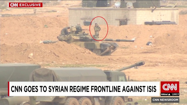 
Hình ảnh những người được cho là quân nhân Nga (khoanh tròn đỏ) bên cạnh xe tăng T-90A xuất hiện trong clip phóng sự của CNN về chiến tuyến chống IS ở miền Đông Syria.
