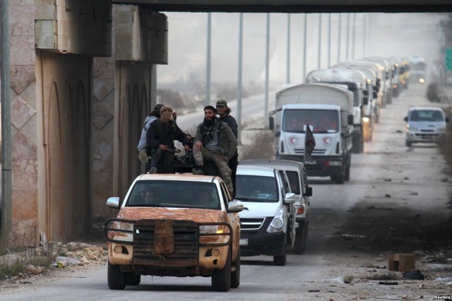 Các chiến binh quân nổi dậy hộ tống đoàn xe cứu trợ nhân đạo tới ngôi làng al-Foua và Kefraya ở tỉnh Idlib, Syria.