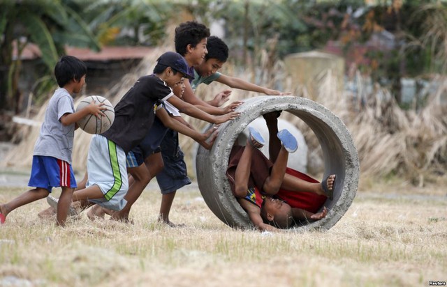 Các cậu bé chơi đùa với ống cống ở ngoại ô thành phố Las Pinas, Philippines.