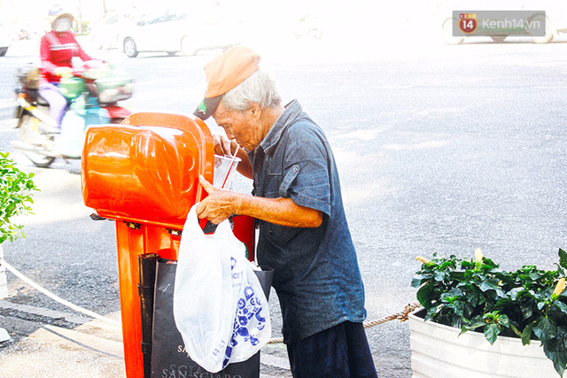 Người đàn ông cắm cúi tận hưởng ly cà phê vừa tìm được trong thùng rác.