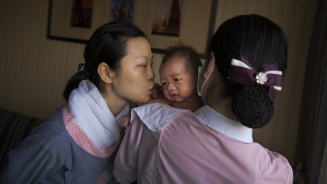 
Một em bé Trung Quốc đang trong vòng tay yêu thương của gia đình - Ảnh: The New York Times
