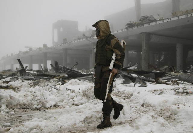 Một thành viên của lực lượng ly khai đi qua tòa nhà bị phá hủy trong cuộc chiến với quân đội chính phủ ở thành phố Donetsk, miền đông Ukraine.