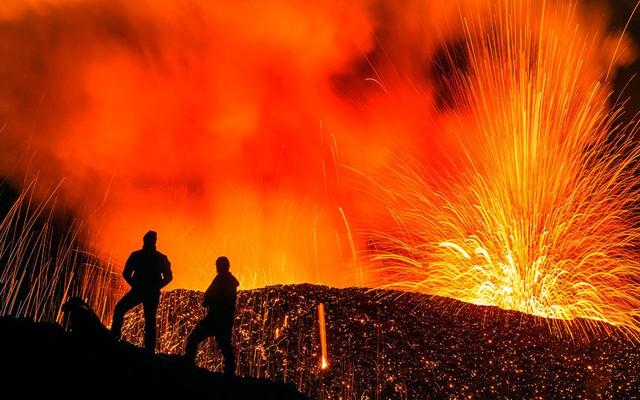 Mọi người chiêm ngưỡng cảnh dung nham phun trào từ núi lửa Piton de la Fournaise trên đảo Reunion thuộc Pháp ở Ấn Độ Dương.