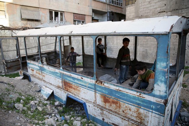 Trẻ em chơi trên chiếc xe bus hỏng tại thị trấn Jesreen do quân nổi dậy kiểm soát gần thành phố Damascus, Syria.
