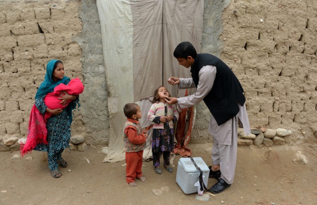 Nhân viên y tế đang cho các em nhỏ uống vaccine phòng bại liệt trong một chiến dịch tiêm phòng ở ngoại ô Jalalabad, Afghanistan.