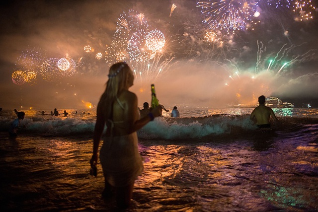 Mọi người chiêm ngưỡng màn bắn pháo hoa rực rỡ mừng năm mới tại bãi biển ở Rio de Janeiro, Brazil.