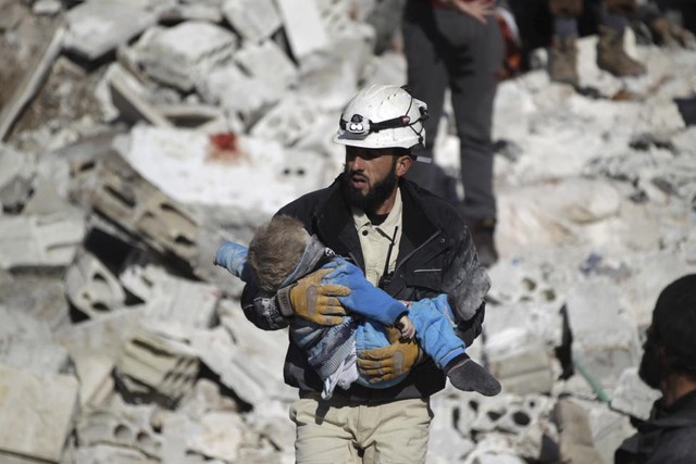 Nhân viên cứu hộ bế một em bé tử vong tại hiện trường vụ ném bom xuống thị trấn Maaret al-Numan ở tỉnh Idlib, Syria.