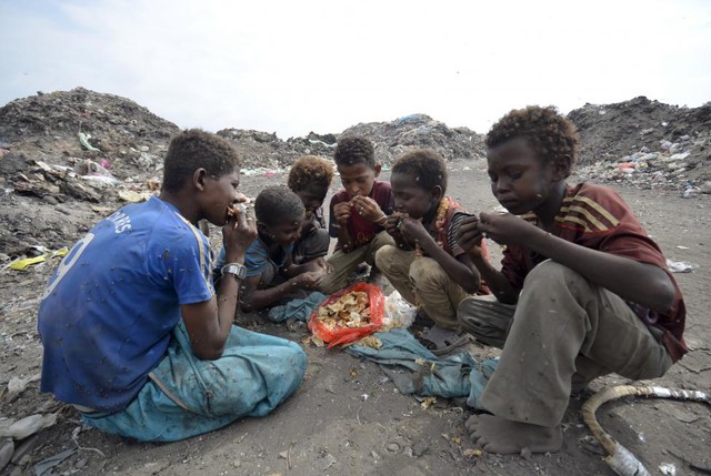 Các cậu bé ngồi ăn ngay tại bãi rác ở thành phố cảng Houdieda, Yemen.
