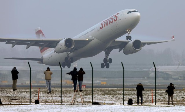 Mọi người chụp ảnh chiếc máy bay Airbus A333-300 cất cánh từ sân bay ở Zurich, Thụy Sĩ.