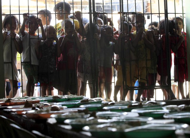 Trẻ em đứng chờ nhận đồ ăn miễn phí tại một khu ổ chuột ở thành phố Manila, Philipines.