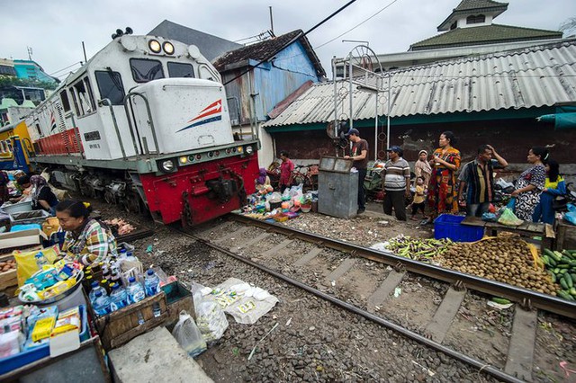 Tàu hỏa di chuyển qua một khu chợ trung tâm tại thành phố cảng Surabaya, Indonesia.