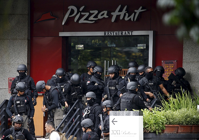 Cảnh sát có vũ trang tập trung bên ngoài một nhà hàng gần hiện trường tấn công khủng bố ở thành phố Jakarta, Indonesia.