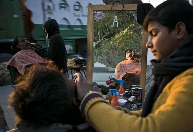 
Khách hàng được cạo râu tại một tiệm cắt tóc ven đường ở thành phố Islamabad, Pakistan.
