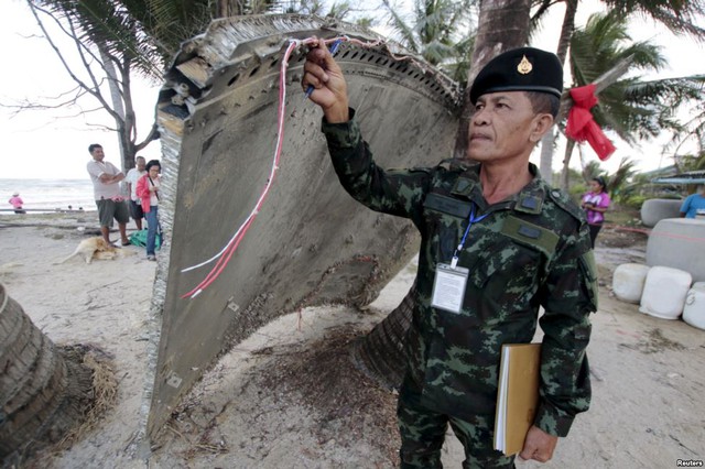 Binh sĩ Thái Lan kiểm tra mảnh vỡ nghi của máy bay mang số hiệu MH370 của hãng không Malaysia Airlines trôi dạt vào bãi biển ở tỉnh Nakhon Si Thammarat.