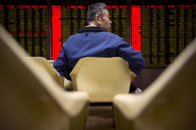 Nhà đầu tư thẫn thờ khi giá cổ phiếu giảm tại một trung tâm giao dịch chứng khoán ở Bắc Kinh, Trung Quốc.