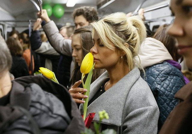 Nhân viên tàu điện ngầm tặng hoa cho nữ hành khách trước ngày Quốc tế phụ nữ 8/3 ở thành phố Kiev, Ukraine.