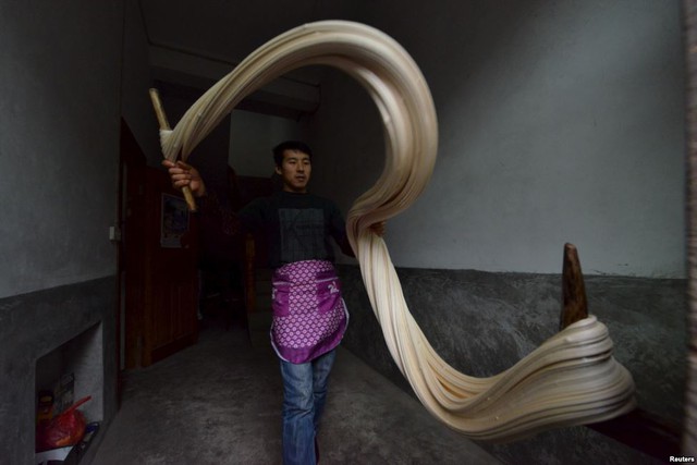 Người đàn ông đang chuẩn bị làm một loại kẹo truyền thống để chuẩn bị cho dịp Tết Nguyên Đán sắp tới ở tỉnh Quý Châu, Trung Quốc.