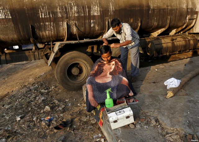 Tài xế lái xe tải được cắt tóc ngay ven đường ở thành phố Mumbai, Ấn Độ.