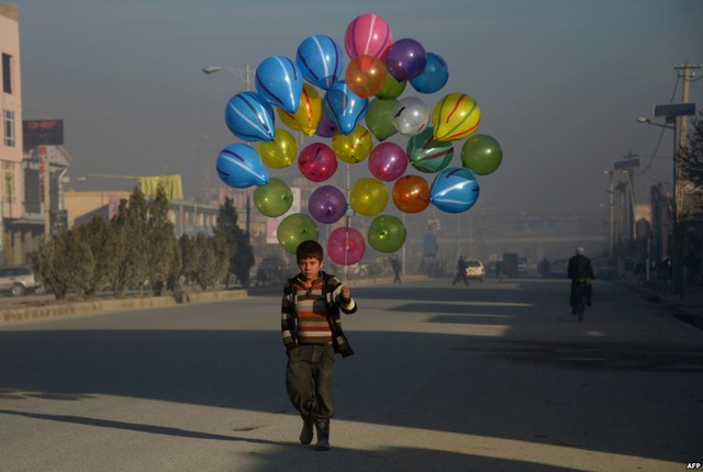 Cậu bé cầm bóng bay đi bán trên đường phố ở Mazar-i-Sharif, Afghanistan.