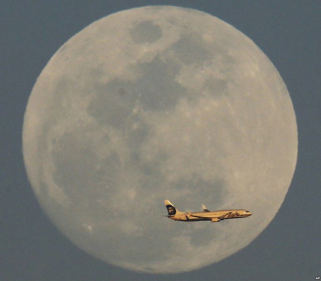 Máy bay của hãng hàng không Alaska Airlines di chuyển qua mặt trăng tròn tại thành phố Phoenix, bang Arizona, Mỹ.