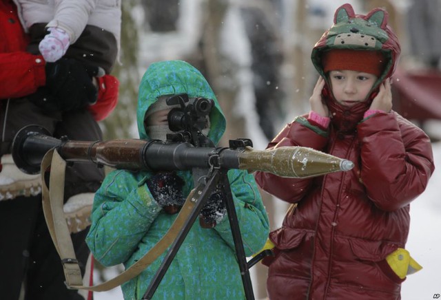 Cậu bé thử sử dụng một khẩu súng phóng rocket vác vai tại triển lãm vũ khí ở St.Petersburg, Nga.