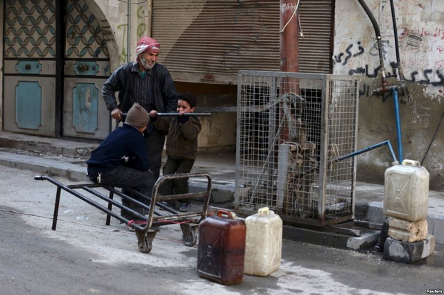 Người dân bơm nước sạch vào can trên đường phố ở Douma, Syria.