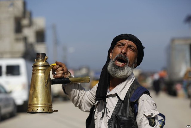 Người đàn ông Palestine bán trà mời gọi khách hàng trên đường phố ở Nusseirat, Dải Gaza.