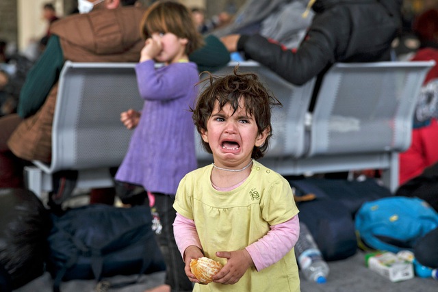 
Bé gái di cư khóc vì sợ hãi sau khi bị tách tạm thời khỏi gia đình tại thành phố Athens, Hi Lạp.
