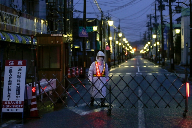 Nhân viên an ninh bảo vệ một khu phố không một bóng người tại thị trấn Namie, Nhật Bản.