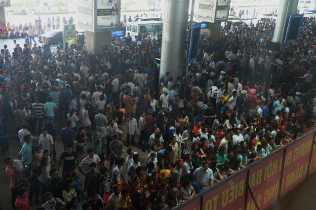 Hàng nghìn người dân chờ đón người thân về quê ăn tết tại ga quốc tế sân bay Tân Sơn Nhất sáng 31-1 - Ảnh: Hữu Khoa