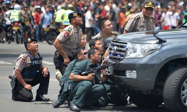 
Cảnh sát Indonesia nấp sau xe trong màn đấu súng với các phần tử khủng bố. Ảnh: AFP
