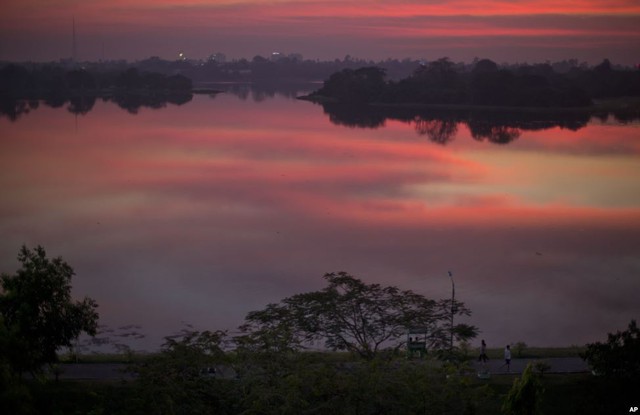 Người dân đi dạo trên bờ hồ lúc hoàng hôn ở Yangon, Myanmar.