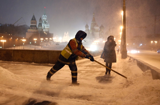 
Công nhân dọn tuyết phủ trên cây cầu bắc qua sông Moskva gần điện Kremlin, Nga.
