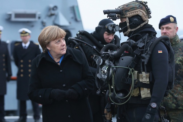 Thủ tướng Đức Angela Merkel kiểm tra một thành viên của Lực lượng đặc nhiệm Hải quân Đức khi bà thăm chiến hạm Braunschweig ở thành phố Kiel.