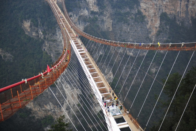 Các công nhân đang hoàn thiện cây cầu nền kính dài nhất và cao nhất thế giới trong vườn quốc gia Trương Gia Giới, tỉnh Hồ Nam, Trung Quốc.