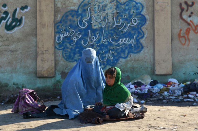 Người phụ nữ và con nhỏ ngồi ăn xin trên đường phố ở Kabul, Afghanistan.