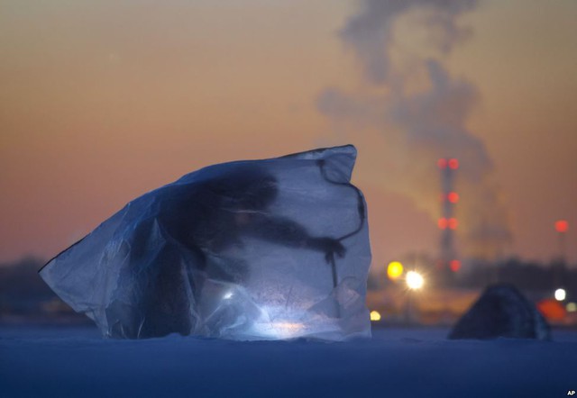 Người đàn ông trùm túi ni lông trong khi câu cá trên hồ nước đóng băng ở thành phố St.Petersburg, Nga.