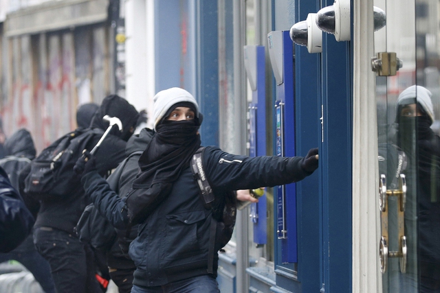 Người biểu tình đập phá máy rút tiền tại một ngân hàng ở Paris, Pháp.