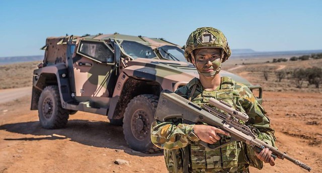 
Một nữ quân nhân Australia đứng cạnh chiếc Hawkei PMV
