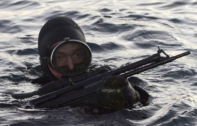 
Một binh sĩ đặc nhiệm chuẩn bị lặn xuống nước để tìm kiếm và tiêu diệt những kẻ có ý định tấn công căn cứ Hải quân
